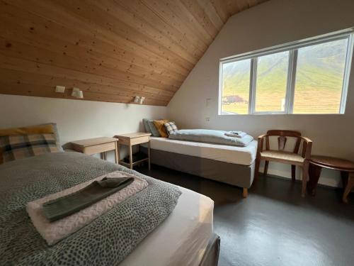 a attic room with two beds and a window at Skyrhusid Guesthouse in Hali