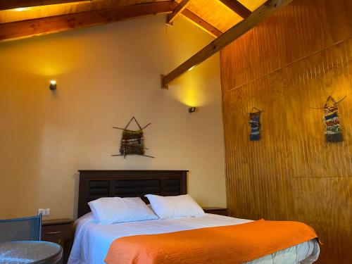 a bedroom with a bed and a wooden wall at Patagonia Bordelago Lodge in Puerto Ingeniero Ibáñez