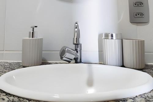 a bathroom sink with a faucet and three candles at Bella Casa Bougainville - APA Barra de Mamanguape in Rio Tinto