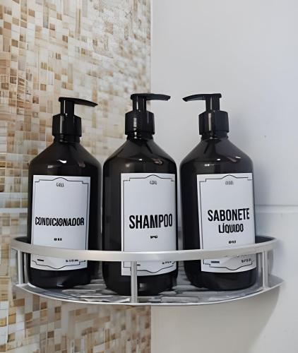 three bottles of shampoo and soap on a shelf at Bella Casa Bougainville - APA Barra de Mamanguape in Rio Tinto