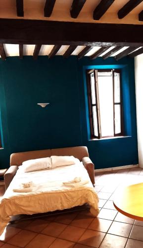 a bed in a room with a blue wall at Va Pensiero Cuore di Parma in Parma
