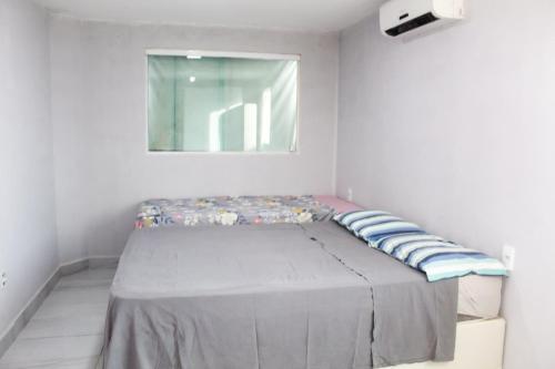 a small bed in a room with a window at Duplex Apartamento em Casa Caiada in Olinda