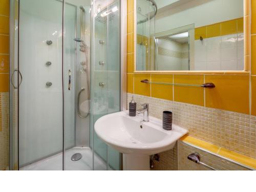 a bathroom with a sink and a glass shower at I Tetti Di Sassari B&B in Sassari