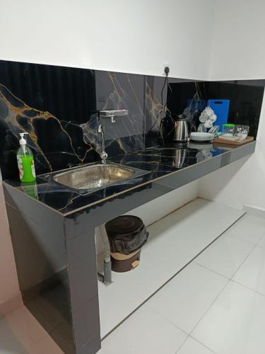 a black counter top with a sink in a room at Magnola Hotels in Bandarawela