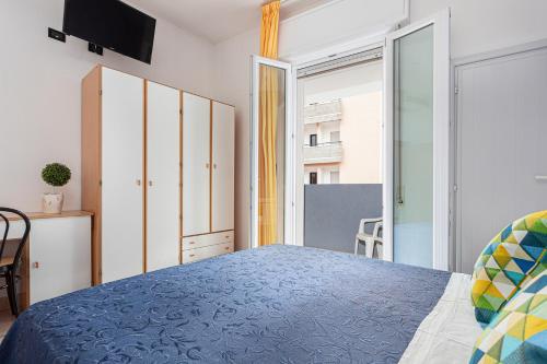 a bedroom with a blue bed and a window at Hotel Solaris in Gatteo a Mare