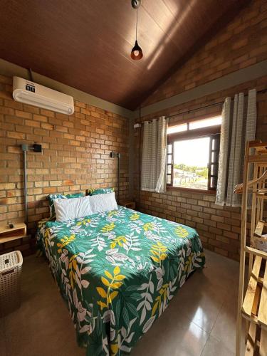 a bedroom with a bed in a brick wall at Bella Casa Ipê 1º andar APA Barra de Mamanguape in Rio Tinto