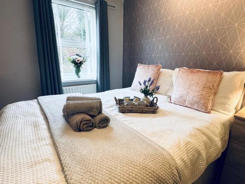 a bed with a basket of towels and a window at New Road Apartment - 2 Bedrooms - Sleeps 3 in Whitehaven