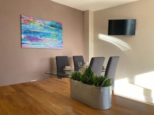 a dining room with a table and a painting on the wall at Newcastle City Penthouse in Newcastle upon Tyne