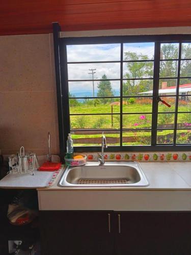 a kitchen sink and a window with a view of a field at Finca La Milagrosa in Cómbita