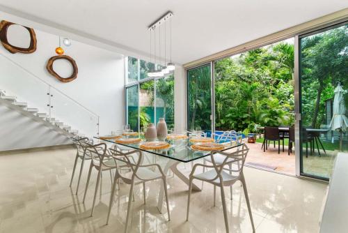 a dining room with a glass table and chairs at Casa Lula 5-BR Getaway in Riviera Maya in Playa del Carmen
