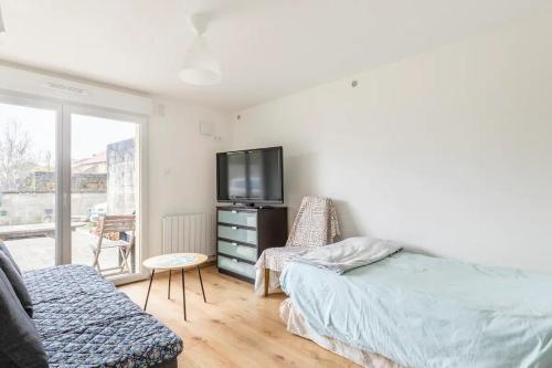 a bedroom with a bed and a tv and a couch at Appartement "L'orée des trois frontières" in Allondrelle-la-Malmaison