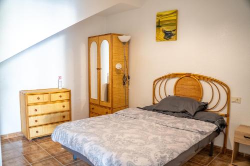 a bedroom with a wooden bed and a dresser at Bungalow and private XXL Terrace in Alicante