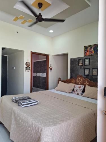 a bedroom with a large bed with a ceiling fan at Lotus Villa Hampi in Hospet