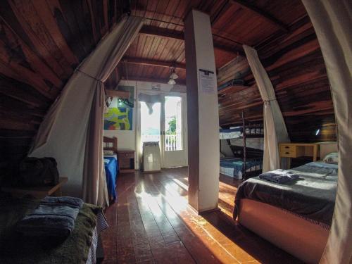 a bedroom with two beds in a room with wooden ceilings at Cabanna Hostel & Turismo in Candelária