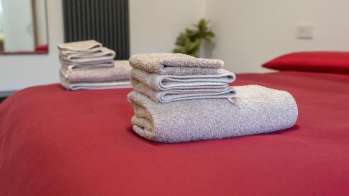 three towels sitting on top of a bed at ESTENSIA Room & Suite in Ferrara