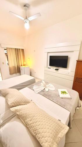 a hotel room with two beds and a flat screen tv at Recanto da Mari in Paraty