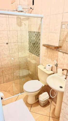 a bathroom with a toilet and a shower and a sink at Recanto da Mari in Paraty