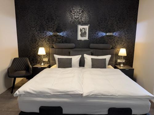 a bedroom with a large white bed with two lamps at Pension Burkhardt in Meißen