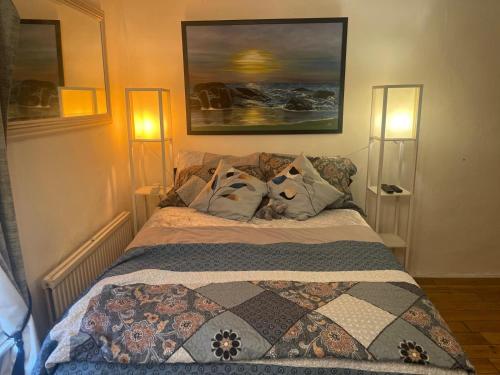 a bed in a bedroom with two lights on at Fenland Gallery in Whittlesey