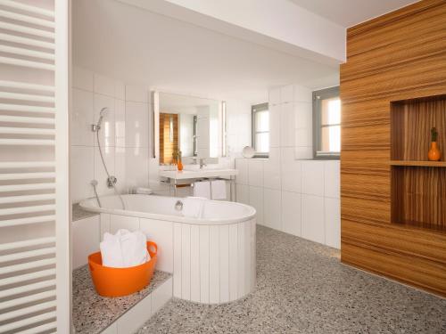 a white bathroom with a tub and a sink at Hotel VICTORIA Nürnberg in Nuremberg