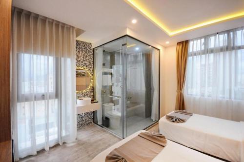 a bathroom with a shower and a bed in a room at Violet hotel 2 in Nha Trang