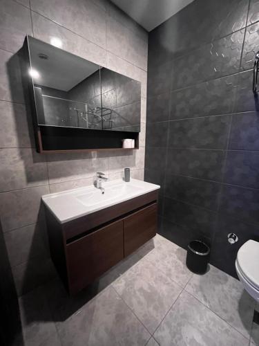 a bathroom with a sink and a mirror and a toilet at Serenity Residens Two bedrooms in Alanya
