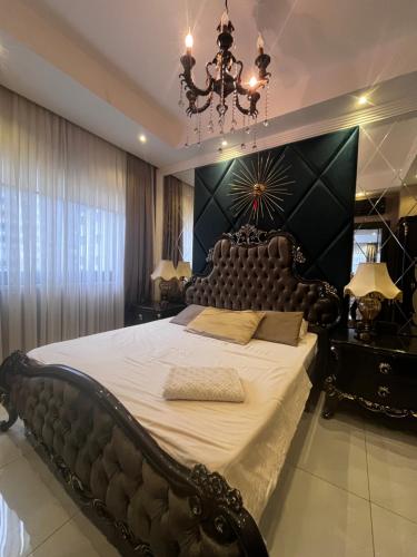 a bedroom with a large bed with a black headboard at Serenity Residens Two bedrooms in Alanya