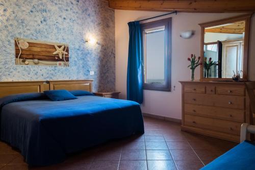 1 dormitorio con cama azul, tocador y espejo en B&B L'Approdo, en Piano di Sorrento