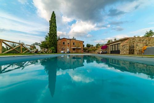a large pool of blue water in front of a building at Villa Sunset in Greve in Chianti