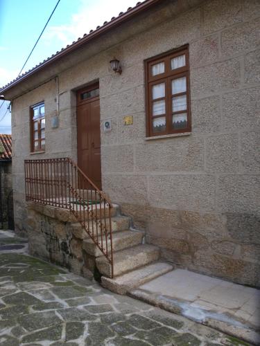 a brick house with stairs leading to a door at Casa de RioBom in Soajo
