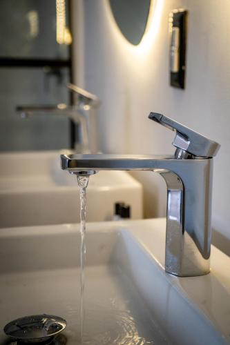 a bathroom sink with water running from a faucet at Priede Hotel Boutique in Puebla