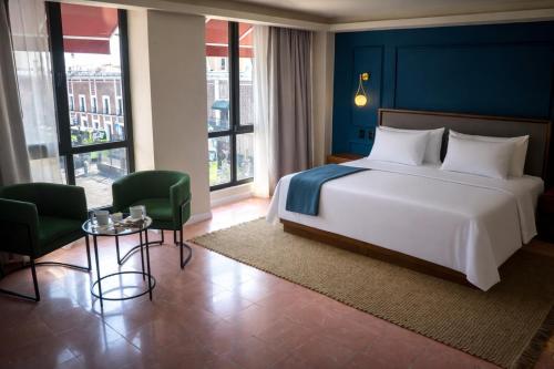 a bedroom with a large bed and a table and chairs at Priede Hotel Boutique in Puebla