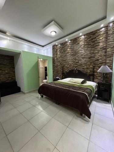 a bedroom with a bed and a brick wall at Comfortable apartment in downtown Reynosa in Reynosa
