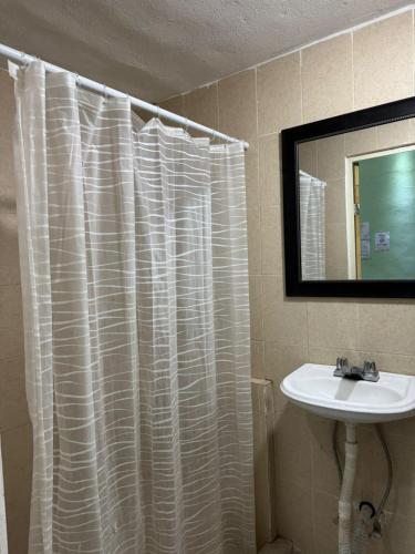 a bathroom with a white shower curtain and a sink at Comfortable apartment in downtown Reynosa in Reynosa