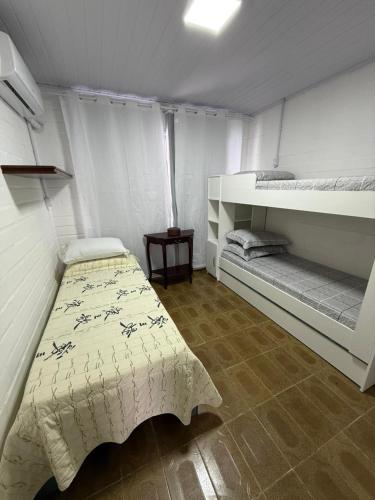 a bedroom with two beds in a room at Chalé 01 centro de itapema 150m do mar in Itapema