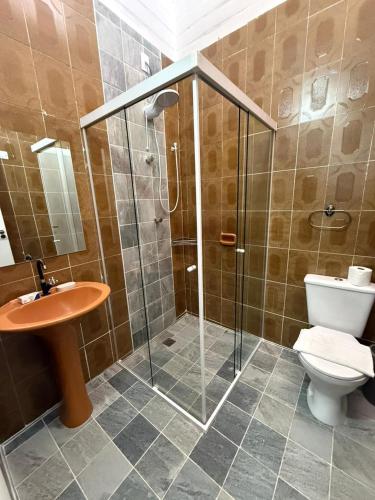 a bathroom with a shower and a toilet and a sink at Chalé 01 centro de itapema 150m do mar in Itapema