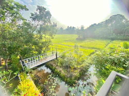 a bridge over a river next to a field at Casa Monkey 28 in Bentota