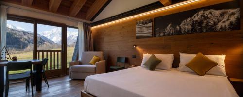 a bedroom with a bed and a balcony with mountains at Chambre d'Hotes Vista Monte Bianco in La Salle