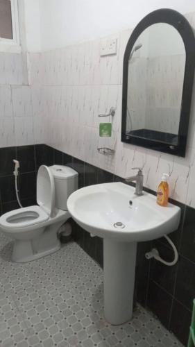 a bathroom with a sink and a toilet and a mirror at New Moon in Pannipitiya
