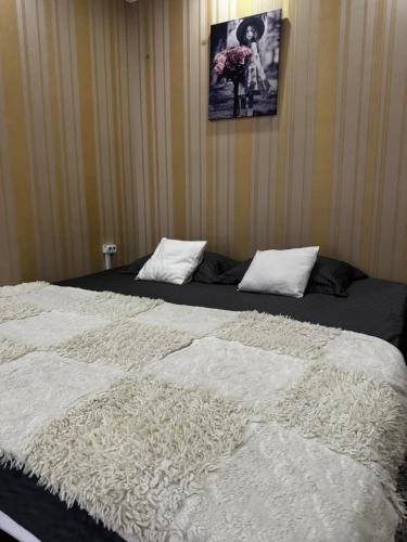 Una cama grande con sábanas blancas y almohadas. en Hôtel Baldei, en Chişinău