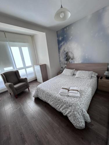 a bedroom with a large bed and a chair at Los Soportales in Soria