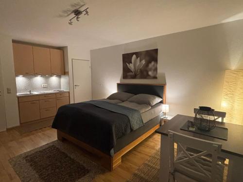 a bedroom with a bed and a table in it at Panorama-Haus Appartment PFÄNDER - Bergblick, Badezimmer, Kitchenette, eigene Sonnenterrasse in Wangen im Allgäu