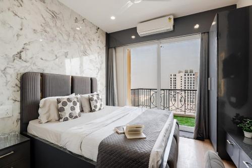 a bedroom with a large bed and a large window at Kaveri Studio Apartment near India Expo Centre in Greater Noida