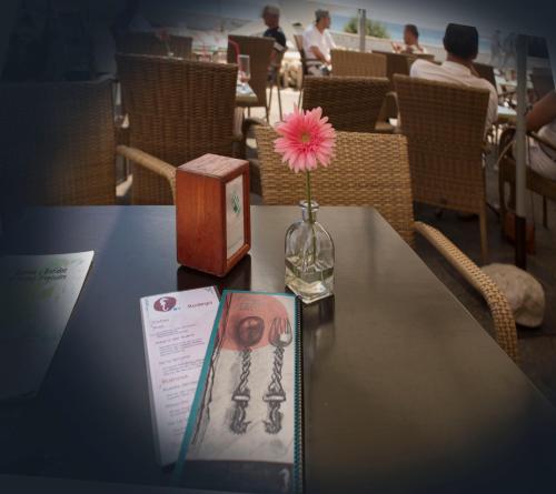 a table with a vase with a flower and a book at Hostal Boutique Casa del Mar Altea in Altea