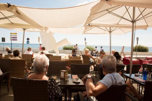 a group of people sitting at a beach restaurant at Hostal Boutique Casa del Mar Altea in Altea