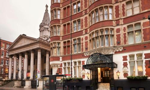 a large red brick building next to a building at Thistle London Holborn in London