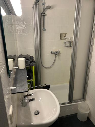 a bathroom with a white sink and a shower at Panorama-Haus Appartment PFÄNDER - Bergblick, Badezimmer, Kitchenette, eigene Sonnenterrasse in Wangen im Allgäu
