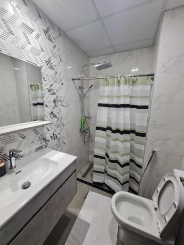 a bathroom with a toilet and a sink and a shower at Fully Equipped Home near Miracle & Butterfly Gardens in Dubai