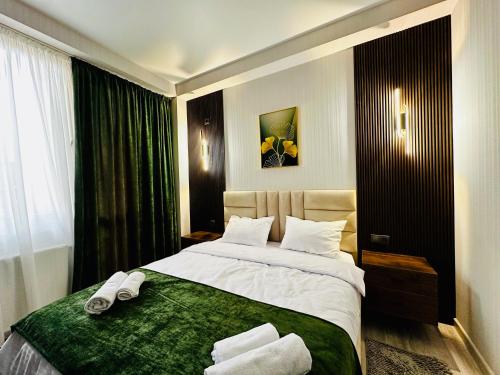 a bedroom with a large bed with towels on it at City Star Kutaisi in Kutaisi