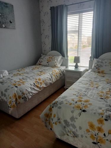 a bedroom with two beds and a window at HomefromHome in Rosslare